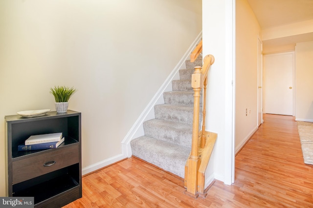 stairway with baseboards and wood finished floors