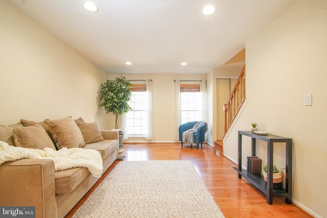 living area with stairway, recessed lighting, light wood-style floors, and baseboards