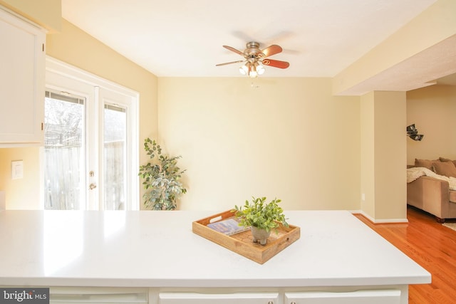 dining room featuring a ceiling fan, light wood-type flooring, and baseboards