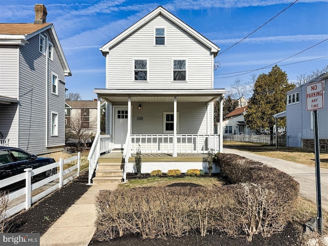 view of front of house featuring covered porch and fence