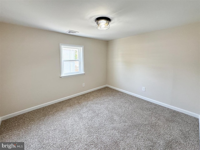 carpeted spare room featuring visible vents and baseboards