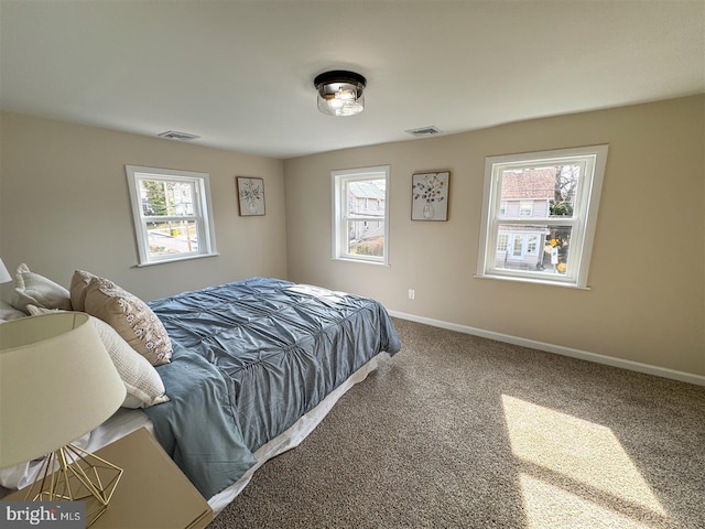 bedroom featuring visible vents, multiple windows, and carpet floors