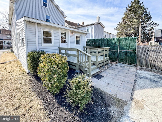 rear view of property with a deck and fence