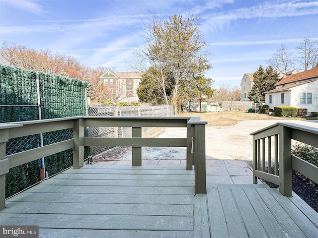 wooden terrace featuring a residential view and a fenced backyard