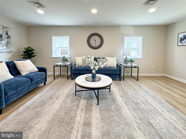 living room featuring recessed lighting, wood finished floors, visible vents, and baseboards