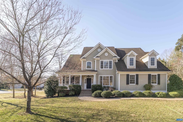 view of front of home with a porch, a front yard, and roof with shingles