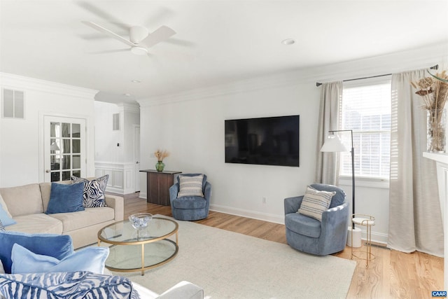 living area featuring visible vents, wood finished floors, a ceiling fan, and ornamental molding