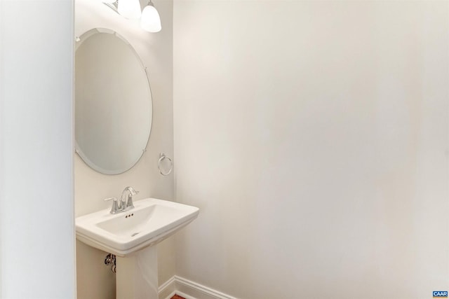 bathroom with a sink and baseboards