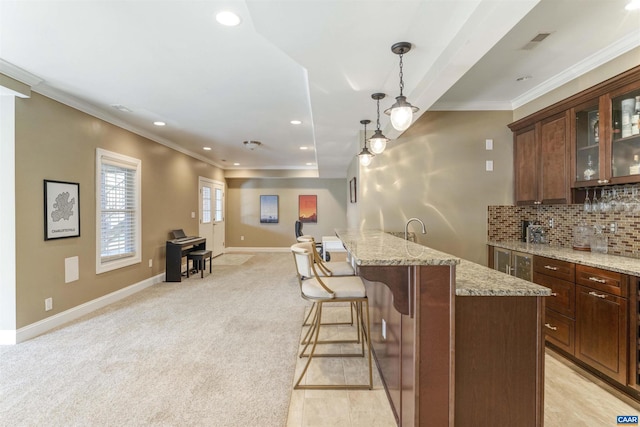 kitchen with visible vents, ornamental molding, glass insert cabinets, light carpet, and tasteful backsplash