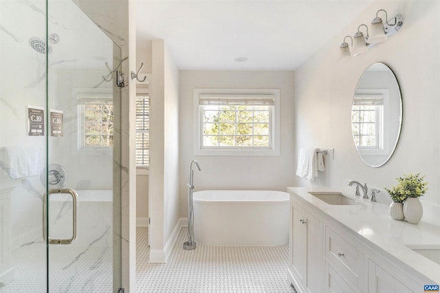 bathroom featuring a marble finish shower, tile patterned flooring, a freestanding bath, double vanity, and a sink