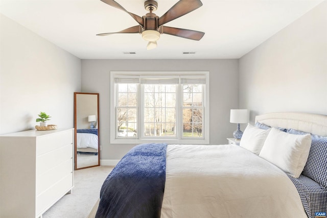 bedroom featuring visible vents, light colored carpet, baseboards, and ceiling fan