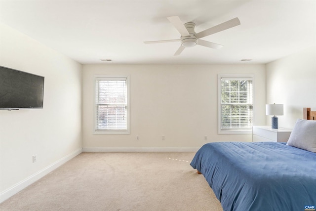 bedroom featuring multiple windows, visible vents, baseboards, and light carpet