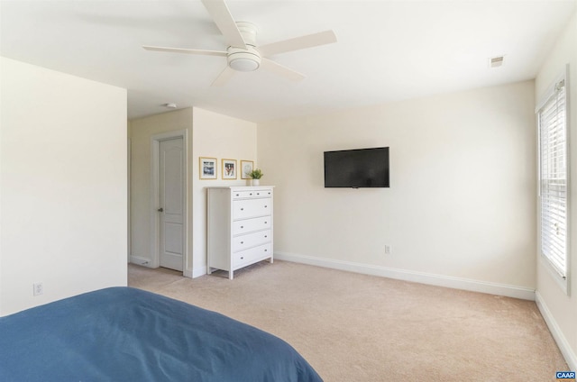 unfurnished bedroom featuring light carpet, visible vents, a ceiling fan, and baseboards