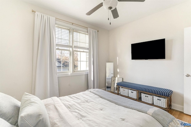 bedroom with baseboards, wood finished floors, and a ceiling fan