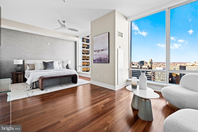 bedroom featuring visible vents, ceiling fan, baseboards, and wood-type flooring