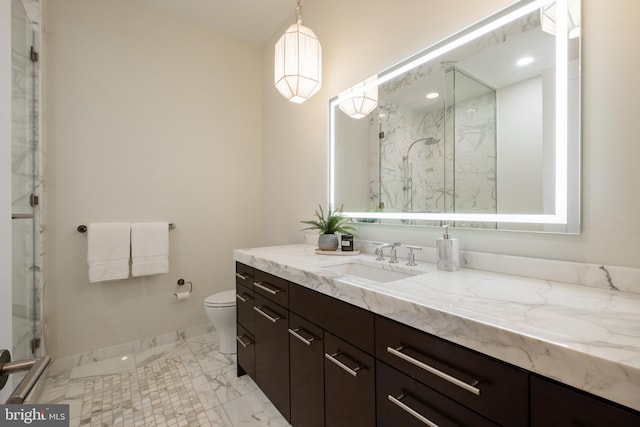 bathroom featuring toilet, marble finish floor, a marble finish shower, baseboards, and vanity