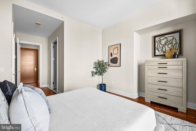 bedroom featuring baseboards and dark wood-type flooring