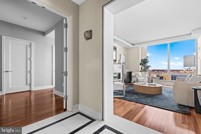 interior space with baseboards, wood finished floors, and floor to ceiling windows