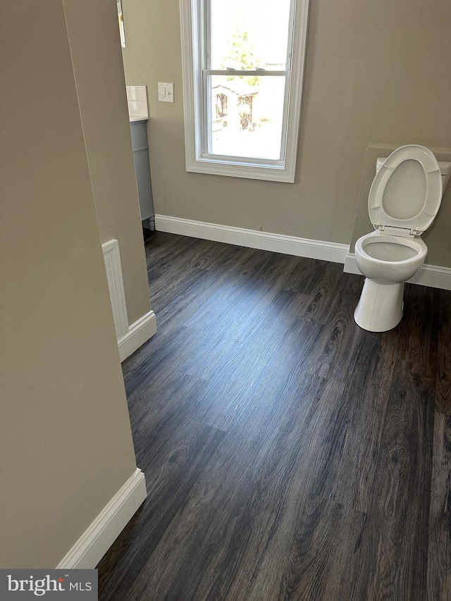 bathroom featuring toilet, baseboards, and wood finished floors