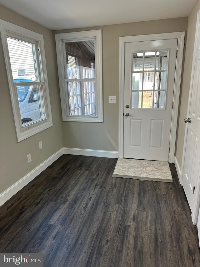 doorway featuring dark wood-style floors and baseboards