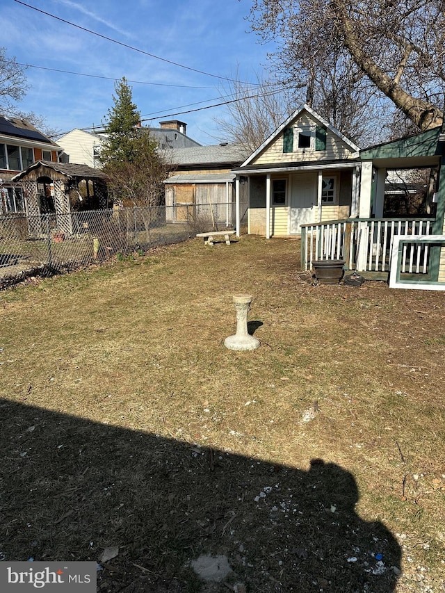 view of yard featuring a porch and fence