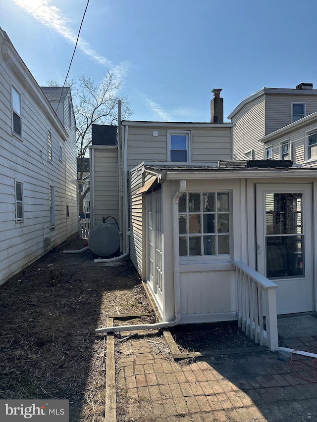 back of house with a chimney