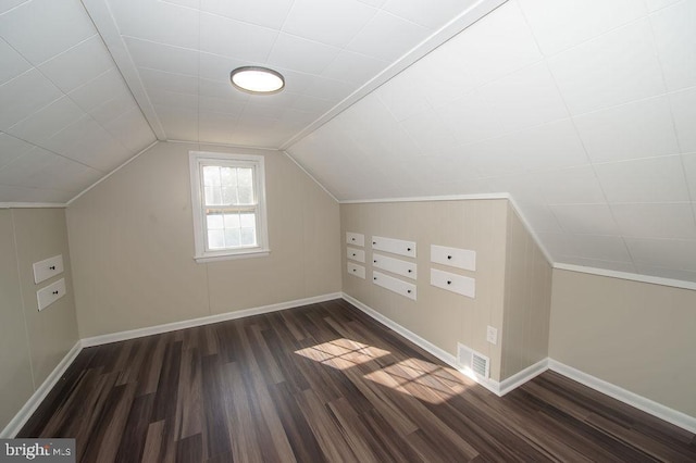 bonus room featuring dark wood-type flooring, baseboards, visible vents, and lofted ceiling