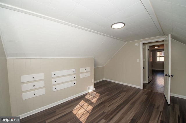 additional living space with baseboards, lofted ceiling, and dark wood-style flooring