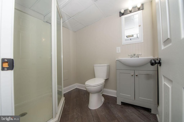 bathroom featuring a shower stall, baseboards, toilet, wood finished floors, and vanity