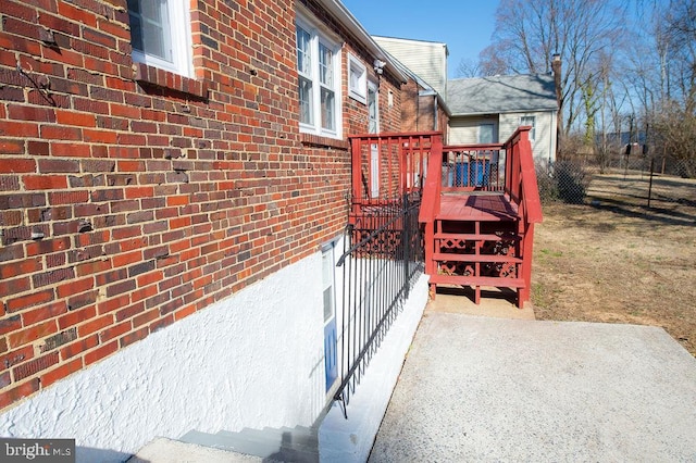 view of side of property featuring a deck and brick siding