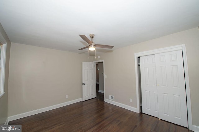 unfurnished bedroom with a ceiling fan, baseboards, visible vents, dark wood-type flooring, and a closet