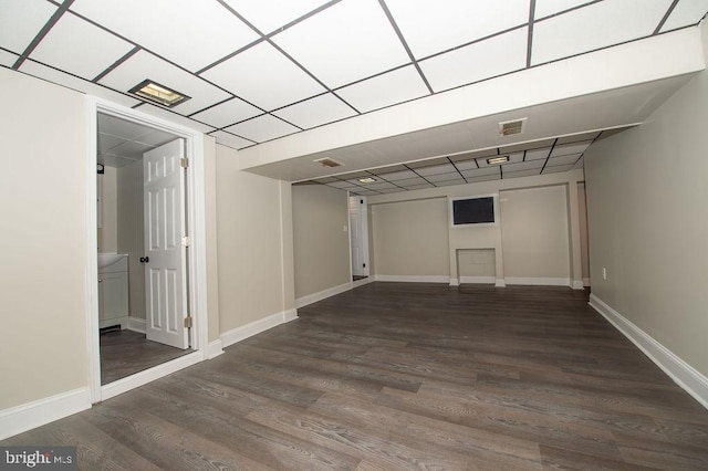 below grade area with a fireplace, wood finished floors, visible vents, and baseboards