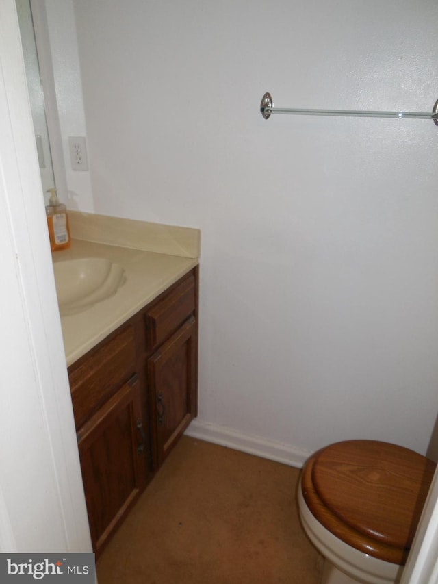 bathroom with vanity, toilet, and baseboards