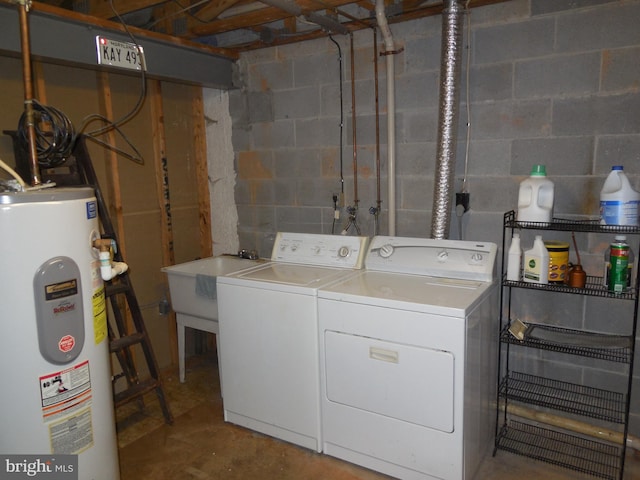 laundry room featuring concrete block wall, laundry area, water heater, a sink, and washer and dryer