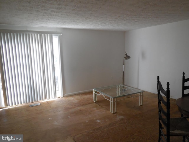 unfurnished dining area featuring a textured ceiling