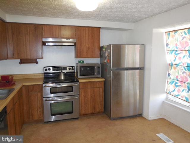 kitchen with under cabinet range hood, visible vents, appliances with stainless steel finishes, and brown cabinetry