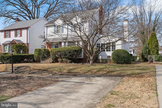 view of front of house featuring a chimney and a front yard