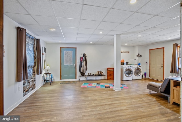 interior space with washing machine and clothes dryer, baseboards, a drop ceiling, recessed lighting, and light wood-style floors