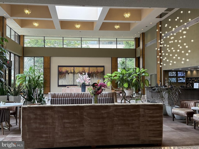 living room featuring beam ceiling, coffered ceiling, and a towering ceiling