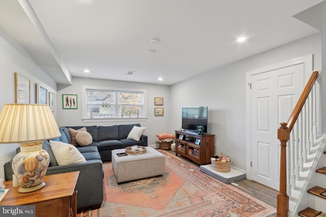 living room with visible vents, baseboards, stairs, recessed lighting, and wood finished floors