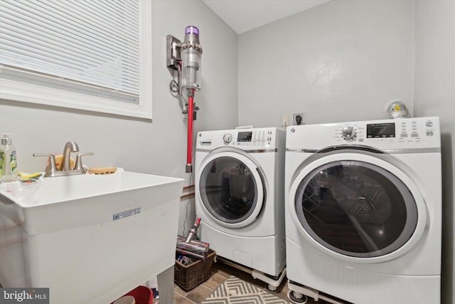 laundry area featuring laundry area, wood finished floors, washing machine and dryer, and a sink