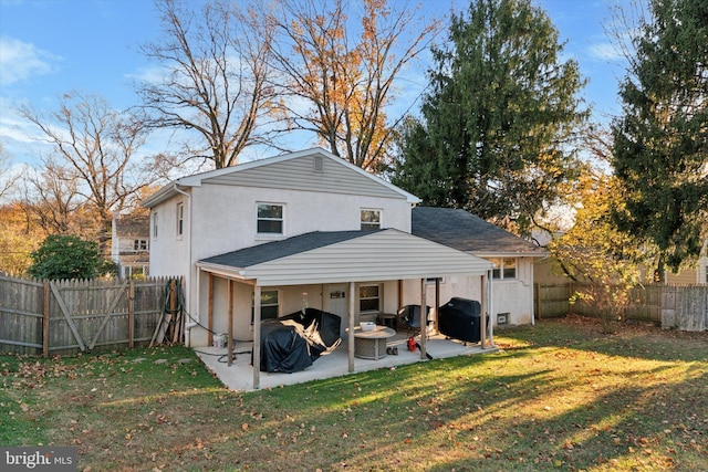 rear view of property featuring a yard, a fenced backyard, stucco siding, and a patio