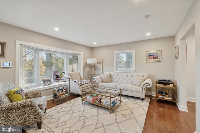 living area with recessed lighting, baseboards, and wood finished floors