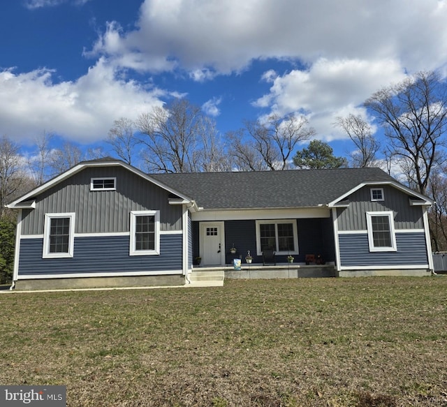 view of front of house with board and batten siding, a front lawn, and roof with shingles