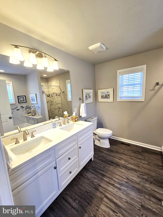 full bathroom with a shower stall, toilet, wood finished floors, and a sink