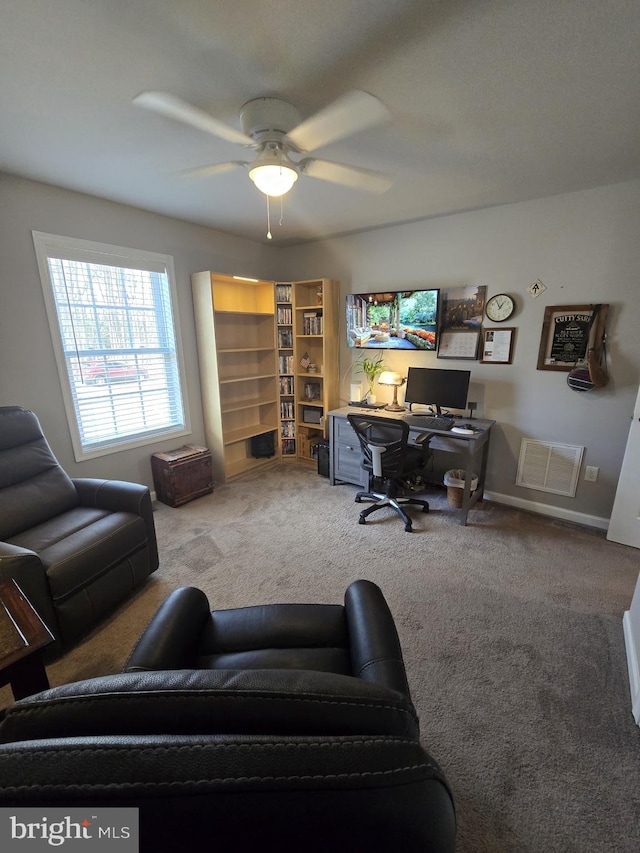 office space with visible vents, baseboards, carpet, and ceiling fan