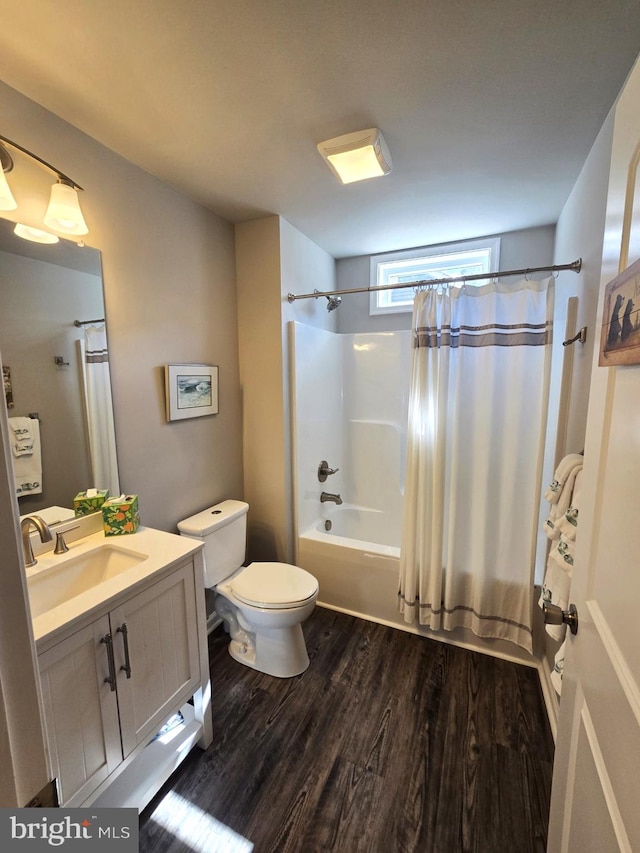 full bath featuring toilet, wood finished floors, vanity, and shower / bath combo