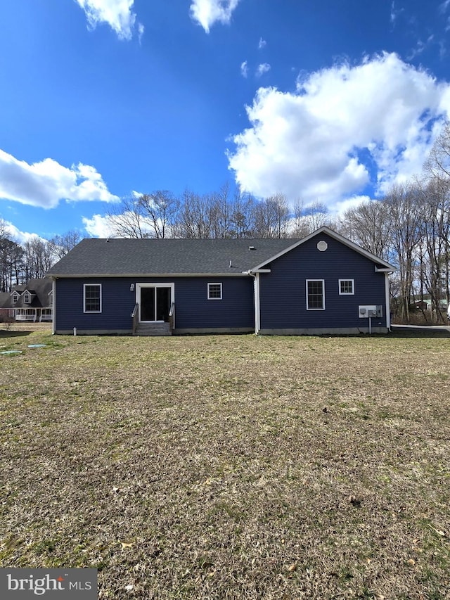 rear view of property featuring a yard