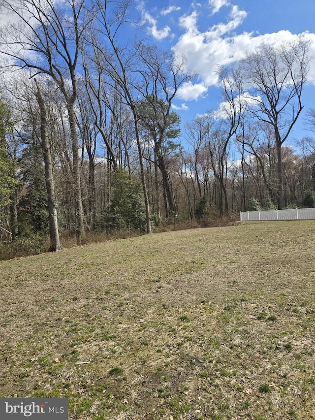 view of yard featuring fence and a view of trees