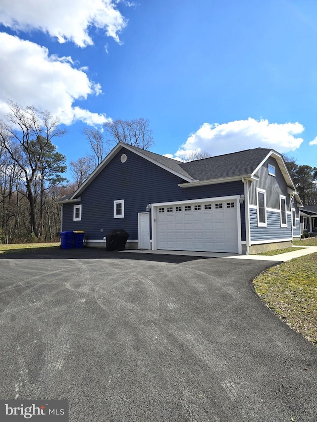 view of side of property with an attached garage and driveway